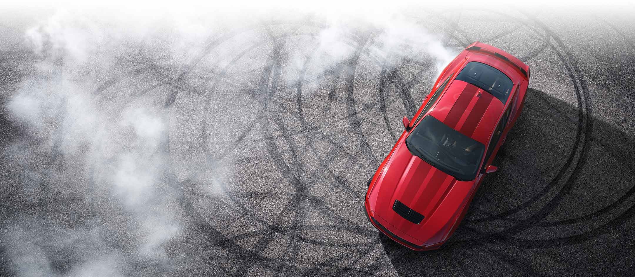 Overhead view of a 2024 Ford Mustang® model with tire tracks on pavement | Midland Ford in Midland MI