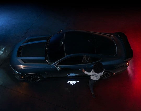 2024 Ford Mustang® Dark Horse™ model with a driver approaching the vehicle | Midland Ford in Midland MI